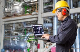 مهندس صناعي يستخدم لوحة بيانات ذكية تشرح ما هي الصيانة التنبؤية لمراقبة أداء المعدات ومنع الأعطال